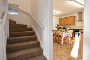 a staircase leading to a kitchen and a dining room at Longhill Farmhouse in Whithorn