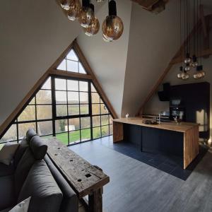 un salon avec un canapé et une grande fenêtre dans l'établissement Les Délices de la Vie, à Le Mesnil-Germain