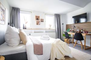 een slaapkamer met een wit bed en een bureau bij HOMEFY STUDIO SKY - free PARKING - ELEVATOR - DESK - NETFLIX in Essen