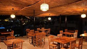 a restaurant with wooden tables and chairs and lights at Larex Otel in Kaş
