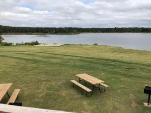 a picnic table sitting on the grass near a lake at Lakefront Cabin - Texoma Coast - 14 in Mead