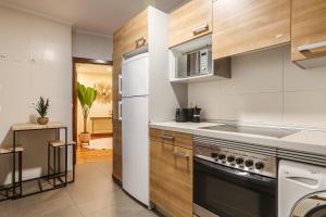 uma cozinha com um frigorífico e um fogão forno superior em Olabeaga apartamento urbano de diseño con wifi em Bilbao