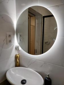 La salle de bains est pourvue d'un lavabo blanc et d'un miroir. dans l'établissement Lisbon South Bay Rooms, à Almada