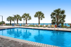 マートルビーチにあるAnderson Ocean Club and Spa by Oceana Resortsのヤシの木が茂るリゾートのスイミングプール