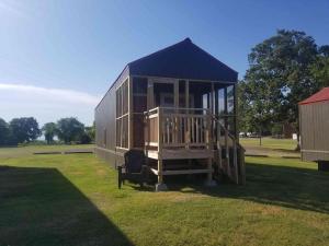a tiny house sitting on the grass in a field at Lakefront Cabin - Texoma Breeze - 12 in Mead +1 photo
