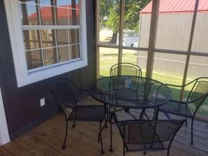 a glass table and chairs on a porch at Lakefront Cabin - Texoma Breeze - 12 in Mead
