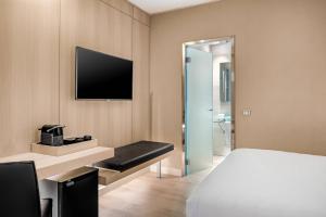 Habitación de hotel con cama y TV en AC Hotel Irla by Marriott, en Barcelona