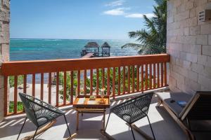 a balcony with a table and chairs and the ocean at Alea Tulum in Tulum