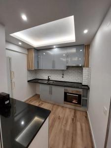 a kitchen with white cabinets and a stainless steel sink at Lisbon South Bay Rooms in Almada