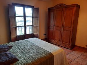 - une chambre avec un lit, une commode et une fenêtre dans l'établissement Casa rural La Casina, à Sariego