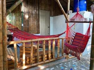 a hammock hanging from a wooden railing in a room at Finca Agroturística La Sultana in El Espinal