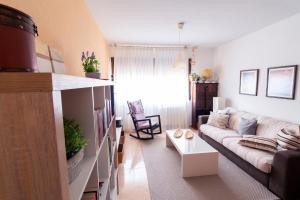 - un salon avec un canapé et une table dans l'établissement Apartamento El Castillo, à La Adrada