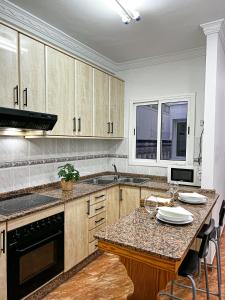 cocina con armarios de madera y encimera en Apartment 100 m from the beach, en Arinaga