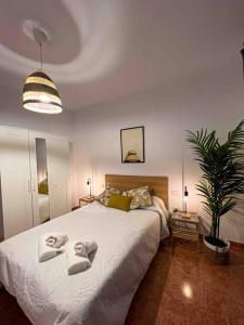 1 dormitorio con 1 cama grande y toallas. en Apartment 100 m from the beach, en Arinaga