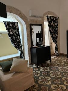 un soggiorno con divano e specchio di Gasparro House a Turi