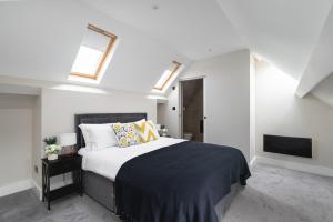 a bedroom with a bed and a tv and skylights at Skyvillion - COZY LARGE 4 Bed Apartments in London Enfield, Mins to Tube Station, Free Wi-Fi in Cockfosters