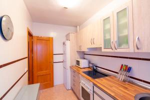 a small kitchen with a sink and a microwave at Apartamento El Castillo in La Adrada +66 photos