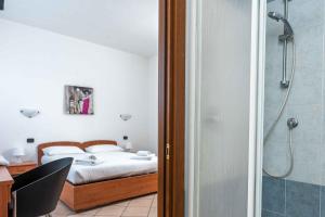 een slaapkamer met een bed en een douche bij Wayco Rooms in Lipomo