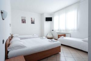 two beds in a room with white walls at Wayco Rooms in Lipomo
