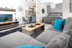 a living room with a couch and a tv and a bed at Studio apartman Orhideja in Vinkovci