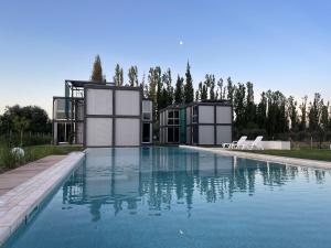 a house with a swimming pool in front of it at Cubos de Chacras in Ciudad Lujan de Cuyo