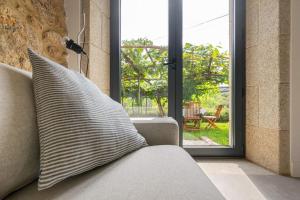 a couch in a living room with a sliding glass door at A casa de Abaixo, aloxamento rural in Vedra