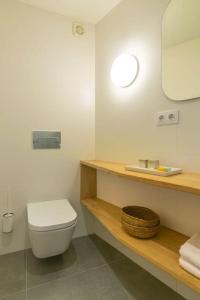 a bathroom with a white toilet and a sink at A casa de Abaixo, aloxamento rural in Vedra