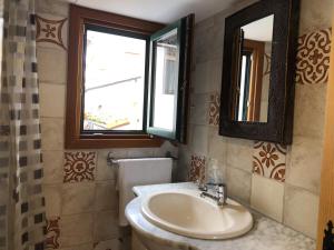 W łazience znajduje się umywalka i lustro. w obiekcie Old town Superbistak w mieście Lekeitio