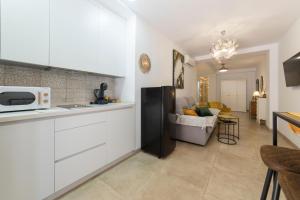 a kitchen with a refrigerator and a living room at Precioso Loft El Arcángel II junto a la Ribera in Córdoba