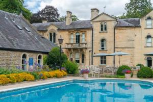 an estate with a swimming pool in front of a building at Beechfield House in Beanacre
