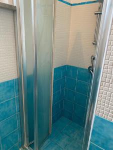 y baño con ducha de azulejos azules. en Ponzamania Da Gino, en Ponza