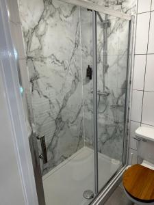 baño con ducha y puerta de cristal en Lucerne B&B en Lyme Regis