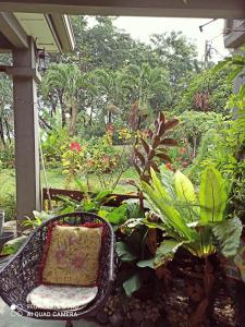 una silla sentada en un porche con plantas en Bdr Bukit Tinggi Klang Tropicana Garden Homestay en Klang