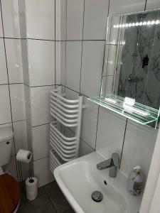 a white bathroom with a sink and a mirror at Lucerne B&B in Lyme Regis