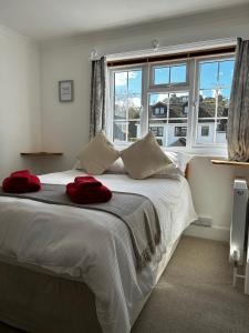 a bedroom with a large white bed with red towels on it at Lucerne B&B in Lyme Regis