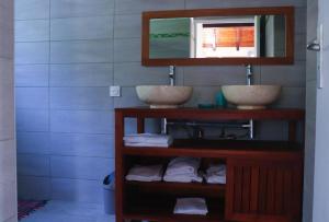 ein Badezimmer mit 2 Waschbecken, einem Spiegel und Handtüchern in der Unterkunft Gîtes de la coulisse in Trois-Rivières