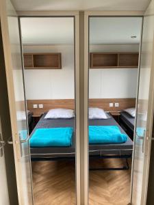 two bunk beds in a room with glass doors at Mobil home 3 chambres mar estang 4 étoiles ! in Canet-en-Roussillon
