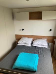 a bed with a blue towel on top of it at Mobil home 3 chambres mar estang 4 étoiles ! in Canet-en-Roussillon