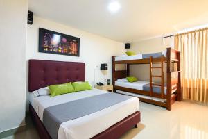 1 dormitorio con 2 camas y 1 litera en Ayenda Colombia Avenida en Medellín