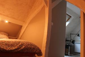 ein Schlafzimmer mit einem Bett mit einem Bettrahmen aus Holz in der Unterkunft La laiterie du Moulin in Montivilliers