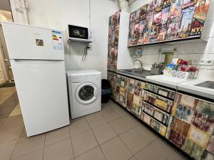 een keuken met een koelkast en een wasmachine bij FOX Hostel Kyiv in Kiev