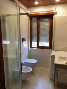 a bathroom with a toilet and a glass shower at Scanno Parco naz Abruzzo Nuovo Appartamento I Gerani,300 m dal centro, vista, wifi garage max 7 persone in Scanno