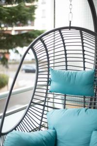 uma cadeira exterior com almofadas azuis num alpendre em Espace Cocooning em Chamalières