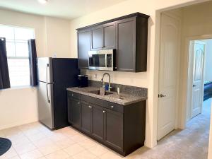 a kitchen with a sink and a refrigerator at Private Lux Apartment in a new community in Fontana