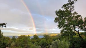 um arco-íris no céu com árvores e água em Hilltop Villa Risika em Risika