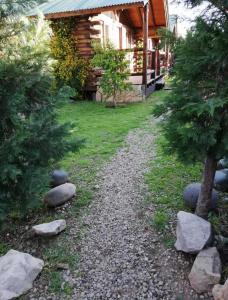 un camino de grava frente a una cabaña de madera en Cabañas Qinti en San Pedro