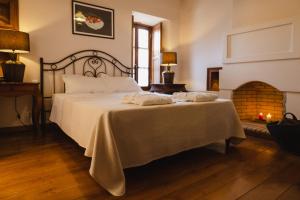 ein Schlafzimmer mit einem großen Bett und einem Kamin in der Unterkunft Ξενώνας Αρχοντικό Ελληνοπύργου in Ellinopyrgos