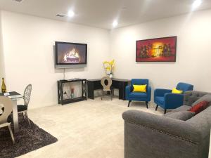 a living room with couches and a tv on the wall at Private Lux Apartment in a new community in Fontana