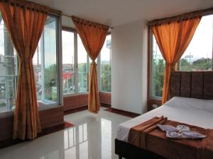 sypialnia z łóżkiem i dużymi oknami w obiekcie Hotel Habitat w mieście Ibagué