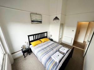 a bedroom with a large bed with yellow pillows at On the Quay in Harwich